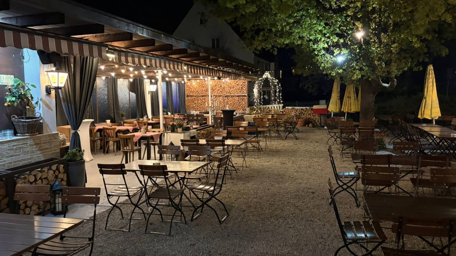 Der Biergarten am Abend, beleuchtet von Lichterketten und Laternen