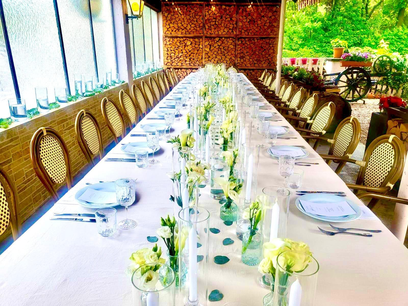 Festlich gedeckte Tafel mit weißen Blumen auf der Terrasse