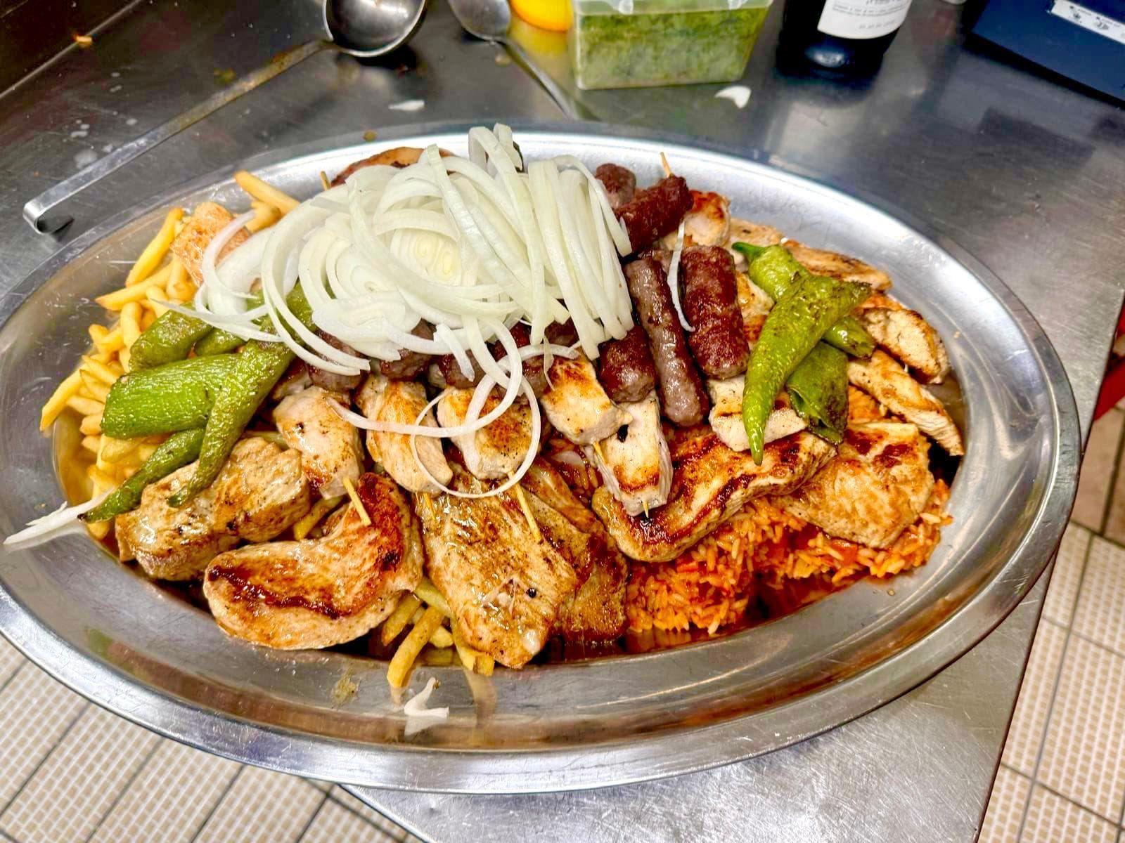Kroatische Grillplatte mit Cevapcici, Fleischspießen, Steaks, Djuvec-Reis und Pommes